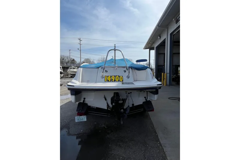 Slide: The Image of 2006 Tahoe 222 boat with blue cover, parked outside a garage, priced at $14,900. - 3