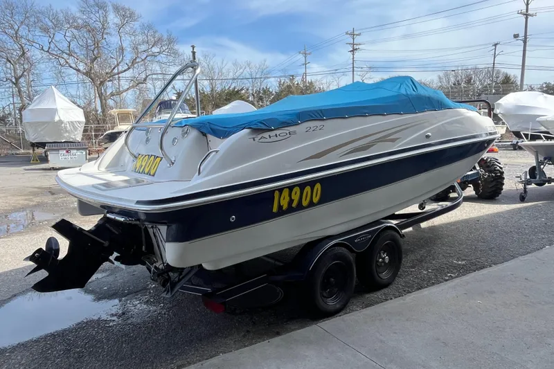 Slide: The Image of 2006 Tahoe 222 boat with blue cover on trailer, parked outdoors. - 4