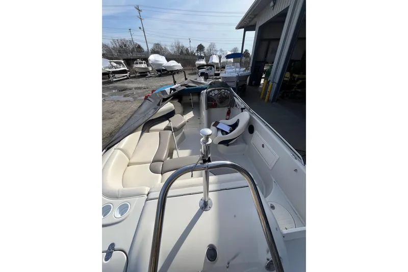 Slide: The Image of 2006 Tahoe 222 boat interior with seating and steering wheel, parked near a storage facility. - 7
