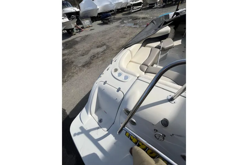 Slide: The Image of 2006 Tahoe 222 boat interior with seating, docked outdoors. - 9