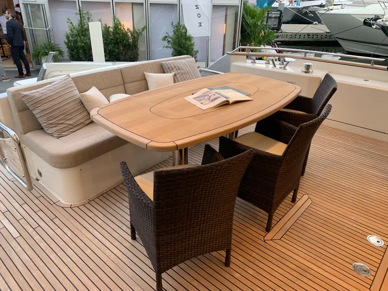 Slide: The Image of Outdoor dining area on 2018 Monte Carlo Yachts MCY 65 with wooden table and wicker chairs. - 24