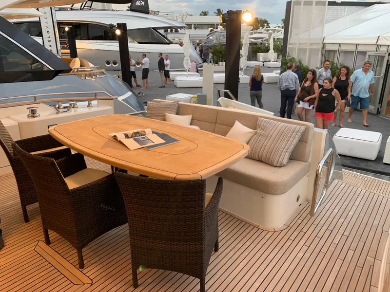 Slide: The Image of 2018 Monte Carlo Yachts MCY 65 deck with dining area and wicker chairs. - 25