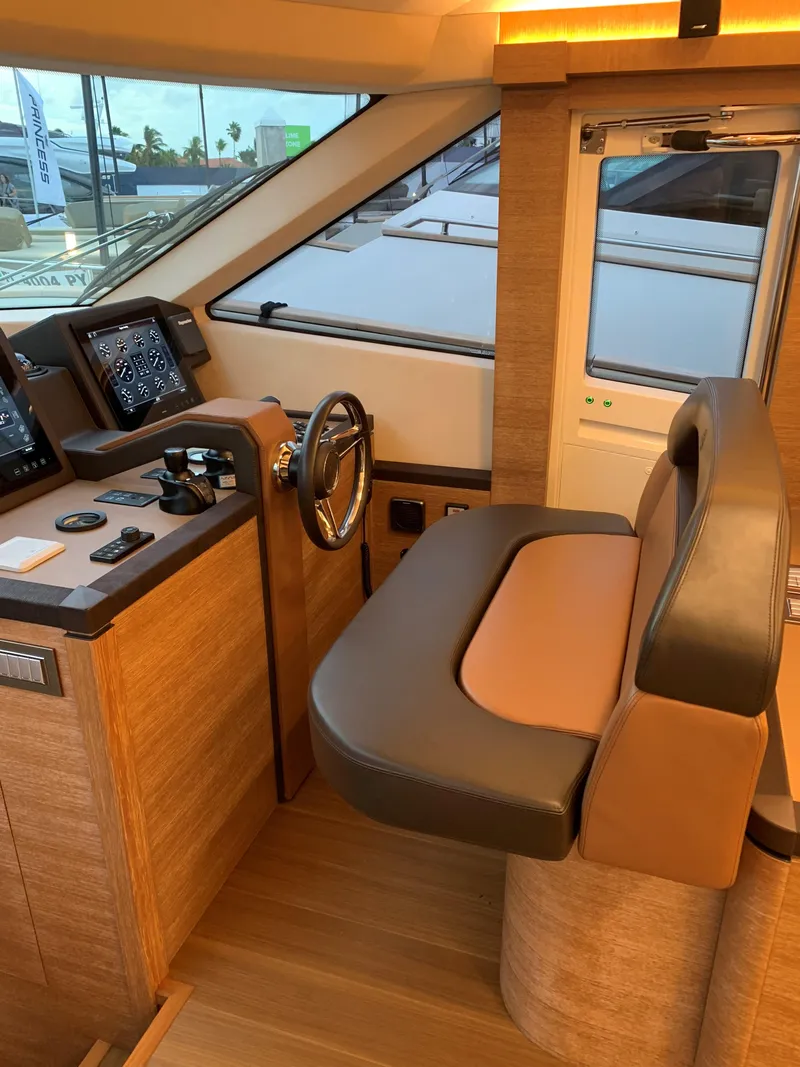Slide: The Image of 2018 Monte Carlo Yachts MCY 65 helm station with modern controls and leather seating. - 47