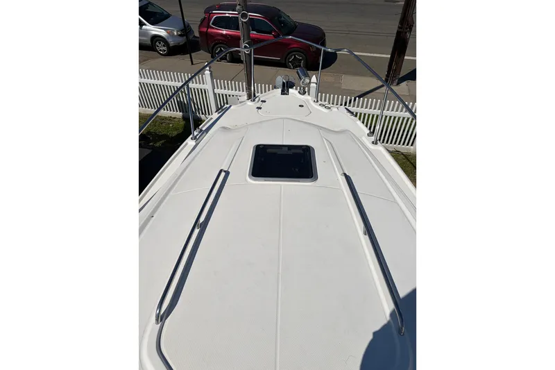 Slide: The Image of 2013 Chaparral 310 Signature boat deck with railing and hatch, parked near street. - 11