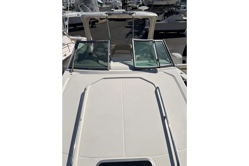 Slide: The Image of 2013 Chaparral 310 Signature boat deck with open windshield, docked at marina. - 13