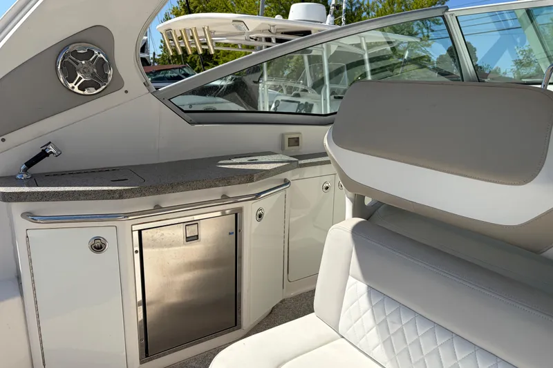 Slide: The Image of Interior of 2013 Chaparral 310 Signature boat with seating and kitchenette area. - 19