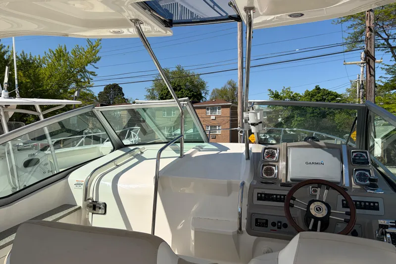 Slide: The Image of 2013 Chaparral 310 Signature boat cockpit with Garmin navigation system, steering wheel, and clear windshield. - 20