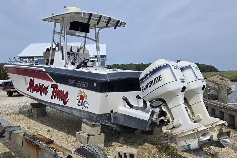 The Image of 1988 Baja 280 Sportfish boat with twin Evinrude engines on a trailer. - 0