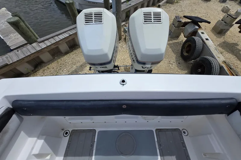 Slide: The Image of 1988 Baja 280 Sportfish boat with dual outboard motors at a dockside. - 12