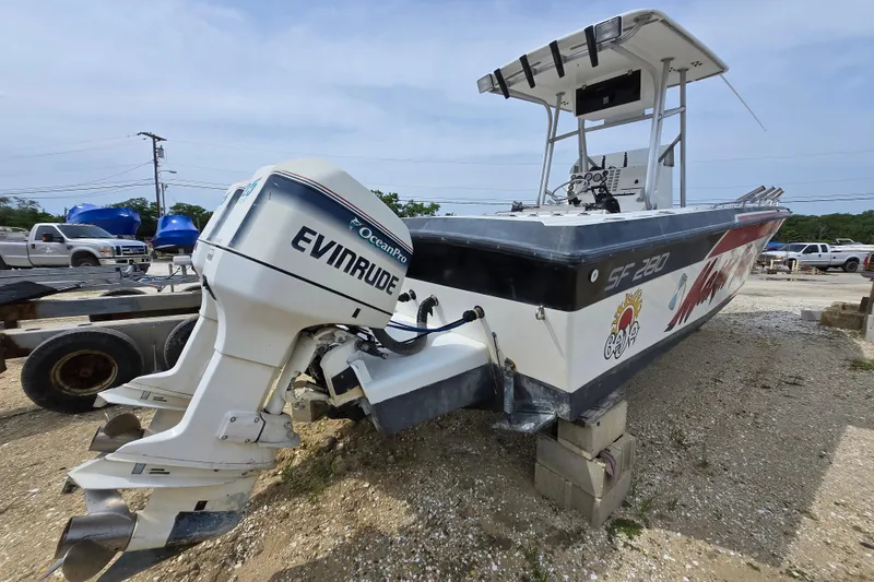 Slide: The Image of 1988 Baja 280 Sportfish boat with Evinrude OceanPro engine on a gravel lot. - 2