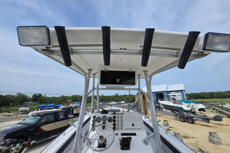 Slide: The Image of 1988 Baja 280 Sportfish boat dashboard with steering wheel and controls, docked outdoors. - 6