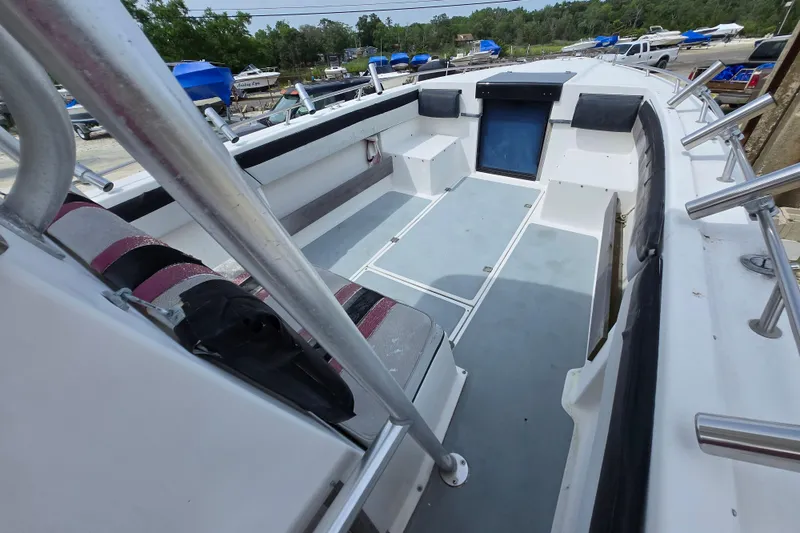 Slide: The Image of 1988 Baja 280 Sportfish boat interior with seating and storage, docked outdoors. - 7