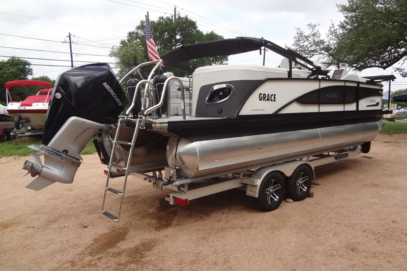 Slide: The Image of 2021 Baraletta Corsa 23 QSS pontoon boat on trailer, featuring Mercury outboard engine. - 2