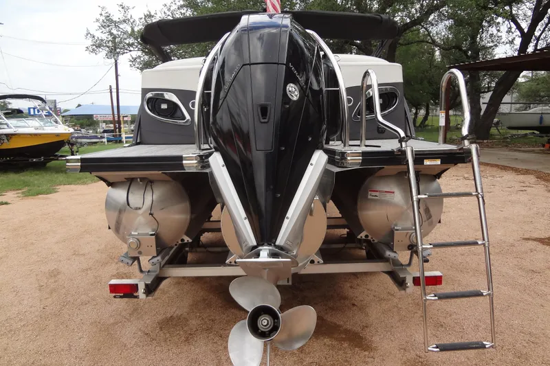 Slide: The Image of 2021 Baraletta Corsa 23 QSS pontoon boat with outboard motor and ladder, parked outdoors. - 3