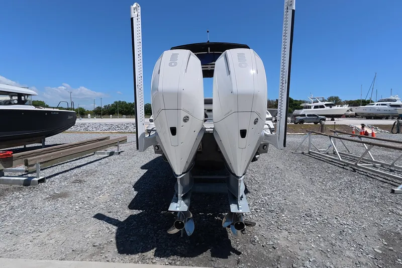 Slide: The Image of 2023 Monterey 305SS Super Sport boat with dual outboard engines on gravel lot. - 4