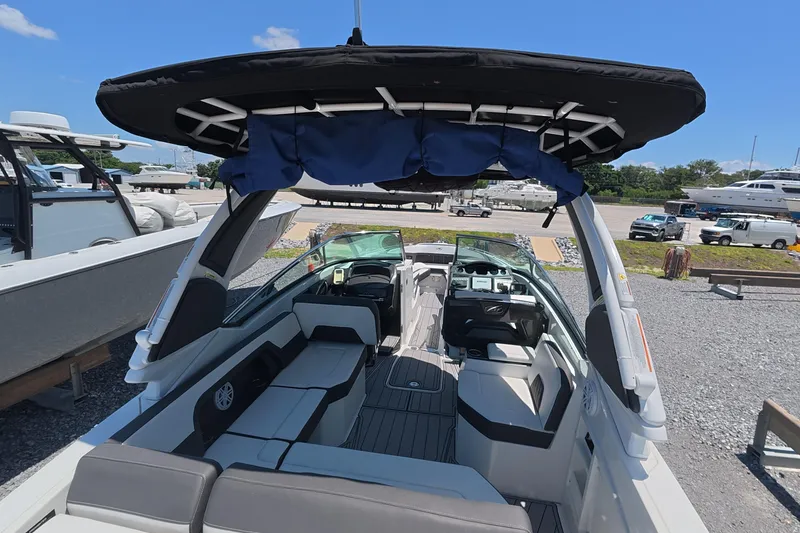 Slide: The Image of 2023 Monterey 305SS Super Sport boat with spacious seating and sleek design at a marina. - 23