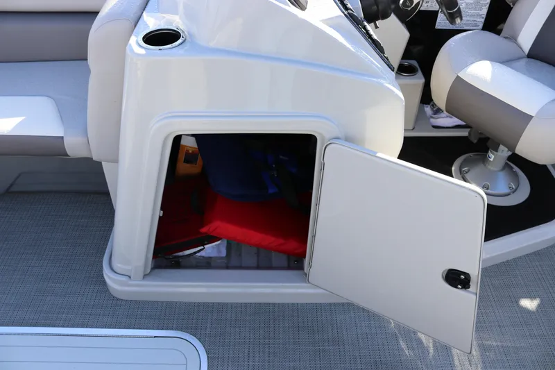 Slide: The Image of Storage compartment on 2024 SunChaser Eclipse LR DH 25 Demo boat, open with visible items inside. - 19