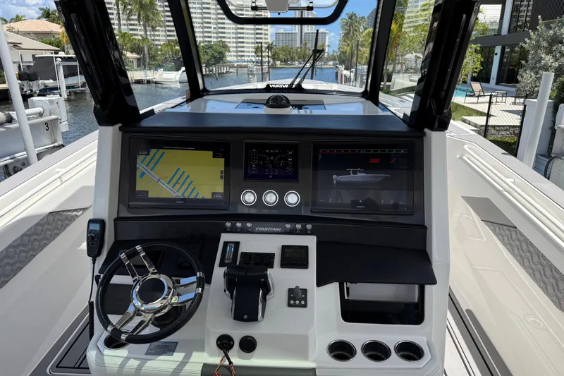 Slide: The Image of 2023 Fountain 38 SCX boat dashboard with navigation screens and steering wheel. - 2