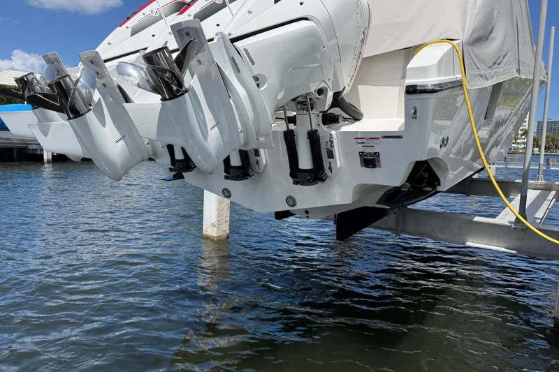 Slide: The Image of 2023 Fountain 38 SCX boat with powerful outboard motors, docked above water. - 25