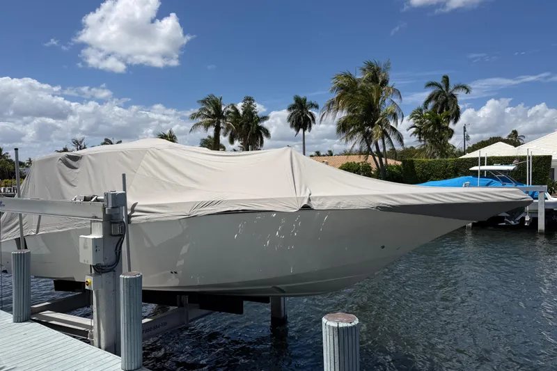 Slide: The Image of Covered 2023 Fountain 38 SCX boat docked near palm trees under a blue sky. - 28