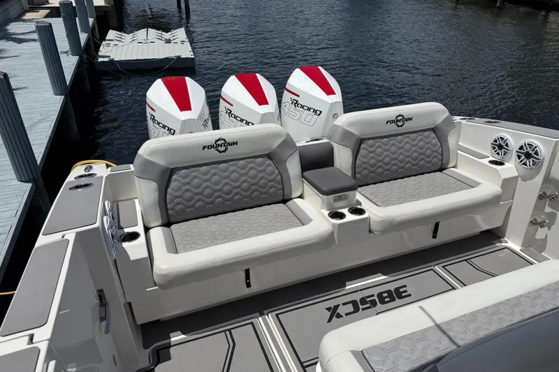 Slide: The Image of 2023 Fountain 38 SCX boat with triple outboard engines and luxurious seating at a dock. - 3