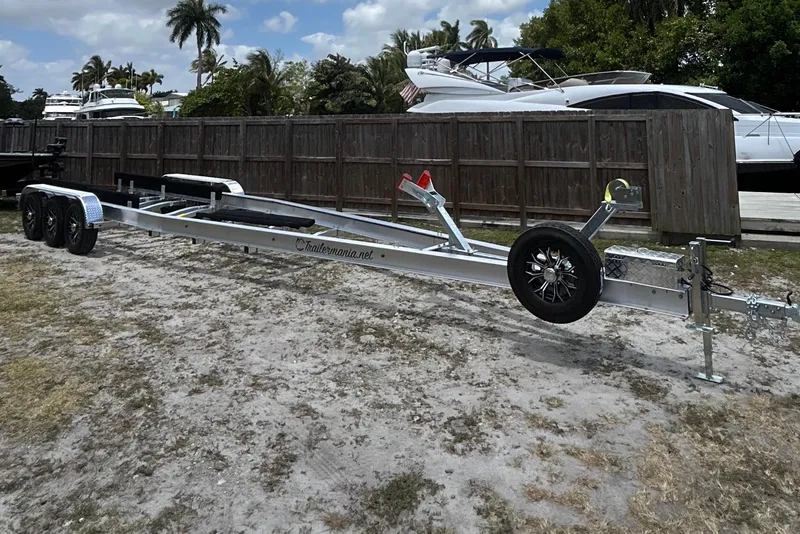 Slide: The Image of Trailer for 2023 Fountain 38 SCX boat, parked outdoors near yachts and palm trees. - 31