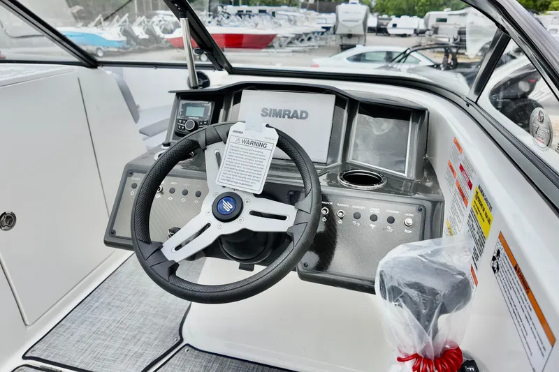 Slide: The Image of 2026 Bayliner VR6 Bowrider OB dashboard with steering wheel and Simrad display. - 11