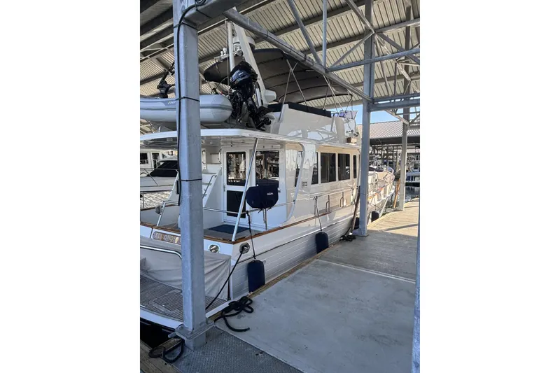 The Image of 2006 Grand Banks 47 Heritage EU yacht docked in a marina under a covered structure. - 0