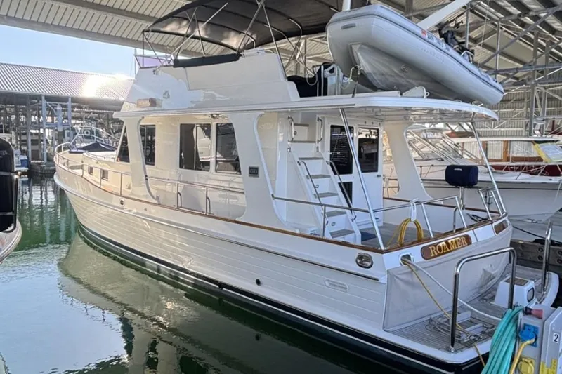 The Image of 2006 Grand Banks 47 Heritage EU yacht docked in a marina under a covered structure. - 3