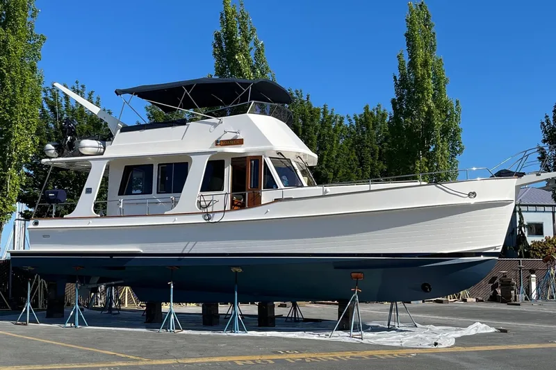 Slide: The Image of 2006 Grand Banks 47 Heritage EU yacht on stands, surrounded by trees and clear blue sky. - 48