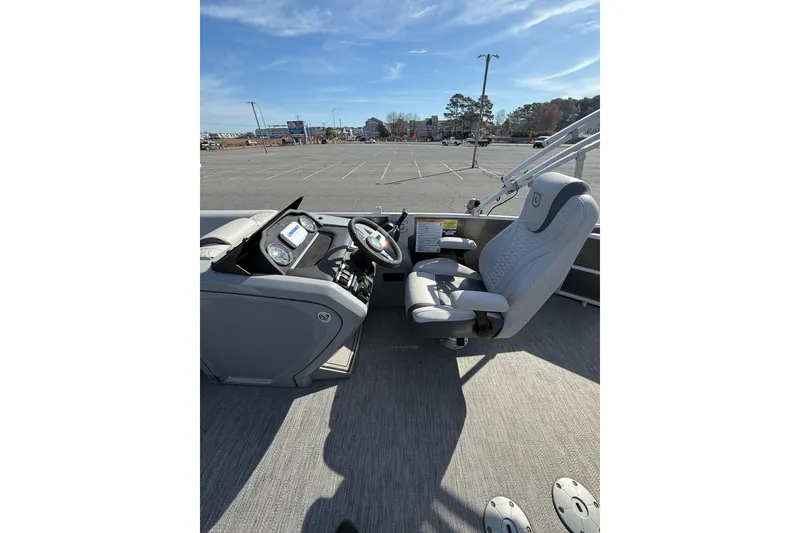 Slide: The Image of Captain's seat and helm of 2021 Godfrey Monaco 215 C boat in a parking lot. - 13