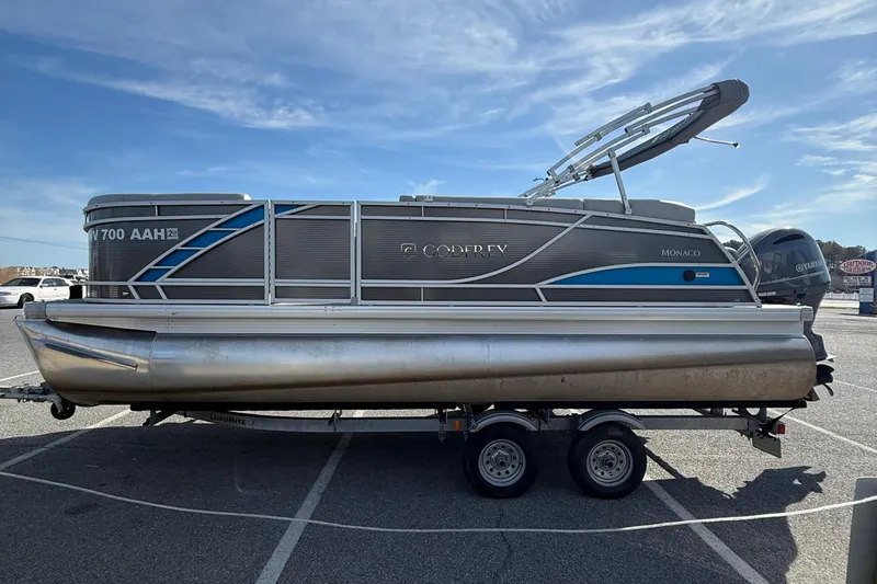 Slide: The Image of 2021 Godfrey Monaco 215 C pontoon boat on trailer, parked in a lot under clear skies. - 5