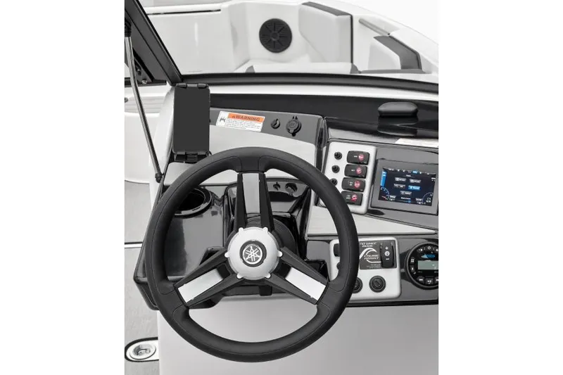 Slide: The Image of 2023 Yamaha Boats AR220 interior with seating and helm, under a clear blue sky. - 3