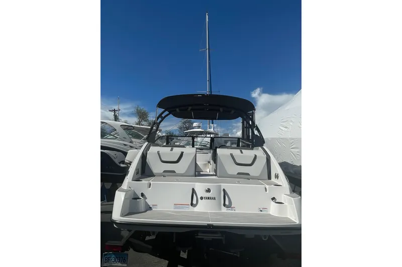 Slide: The Image of 2023 Yamaha Boats AR220, rear view, showcasing sleek design under a clear blue sky. - 9