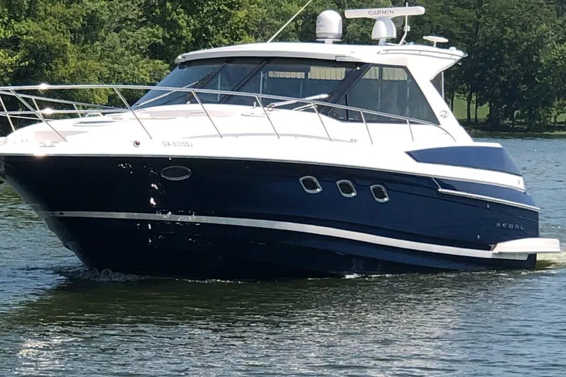 The Image of 2010 Regal 46 Sport Coupe yacht cruising on a serene lake. - 1