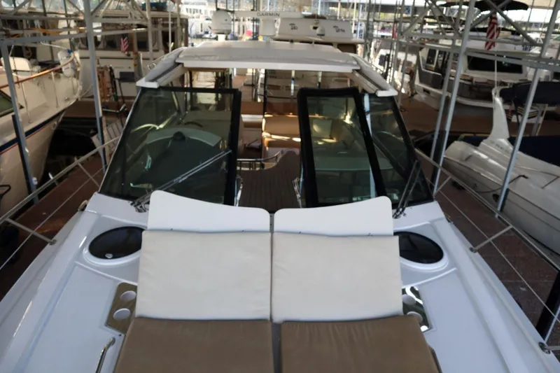 Slide: The Image of 2010 Regal 46 Sport Coupe yacht with sunbathing deck, docked in a marina. - 11