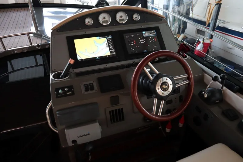 Slide: The Image of 2010 Regal 46 Sport Coupe helm with navigation screens and wooden steering wheel. - 14