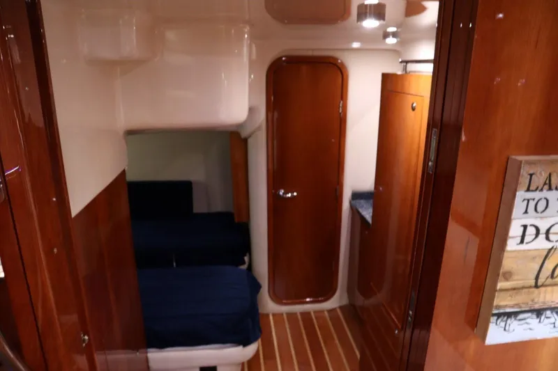 Slide: The Image of Interior cabin of 2010 Regal 46 Sport Coupe with wooden finishes and cozy bedding. - 26