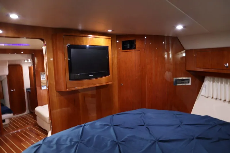 Slide: The Image of Interior of 2010 Regal 46 Sport Coupe yacht with wood paneling and TV. - 28