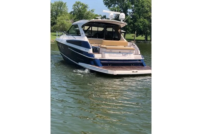 Slide: The Image of 2010 Regal 46 Sport Coupe yacht cruising on a serene lake. - 6