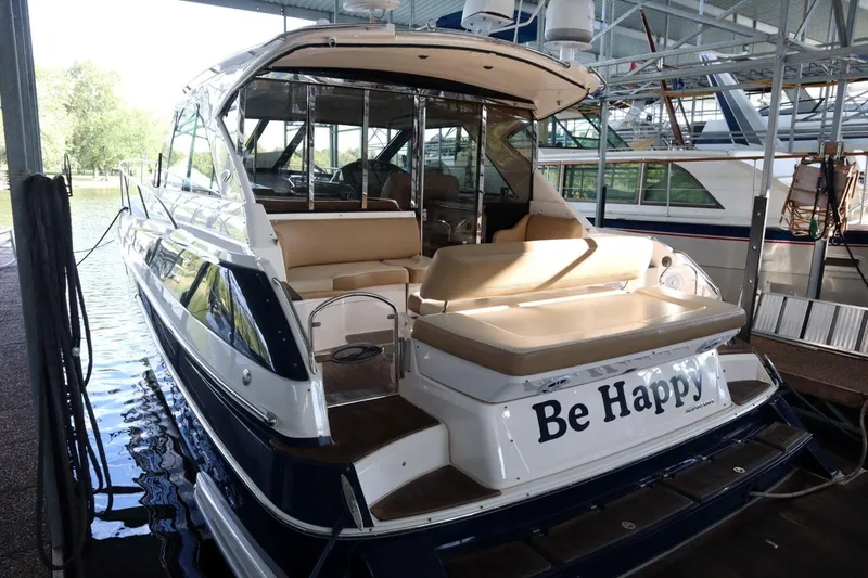 Slide: The Image of 2010 Regal 46 Sport Coupe yacht docked, featuring "Be Happy" on the stern. - 7