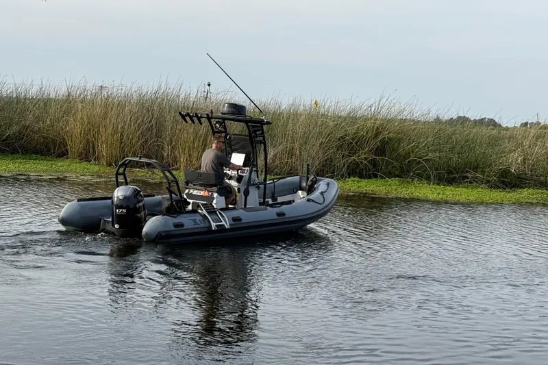Slide: The Image of 2023 Inmar 660R-PT-PR boat navigating a calm waterway near tall grass. - 12