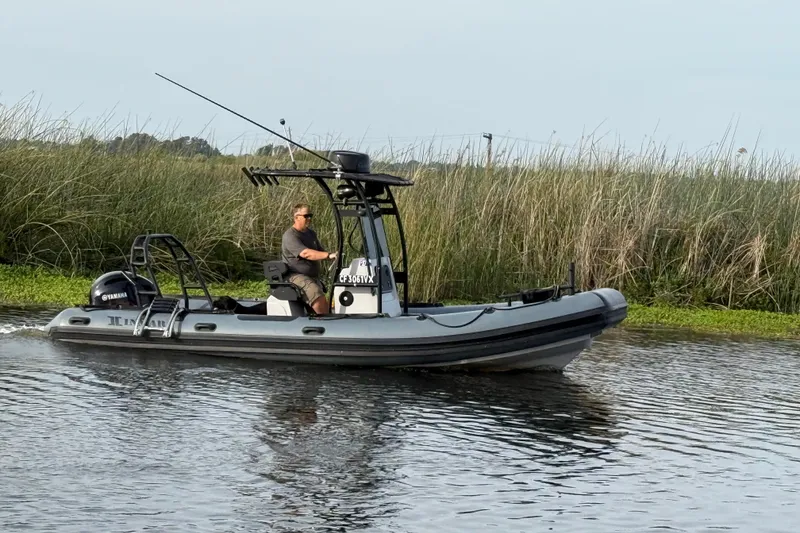 Slide: The Image of 2023 Inmar 660R-PT-PR boat cruising on a river with reeds in the background. - 13