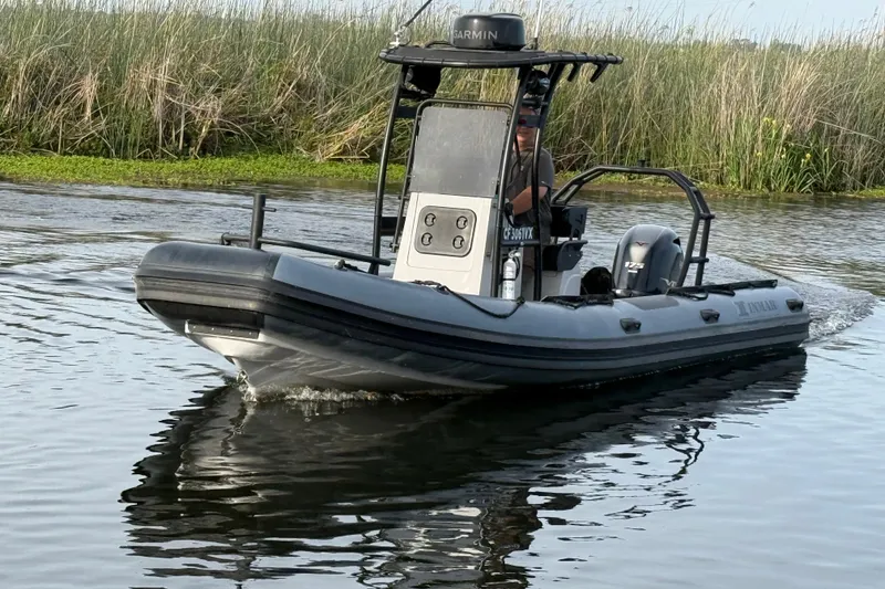 Slide: The Image of 2023 Inmar 660R-PT-PR boat navigating through calm waters near reeds. - 14