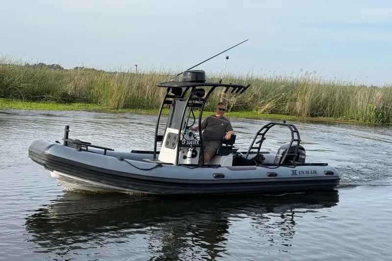 Slide: The Image of 2023 Inmar 660R-PT-PR boat navigating calm waters with lush greenery in the background. - 15