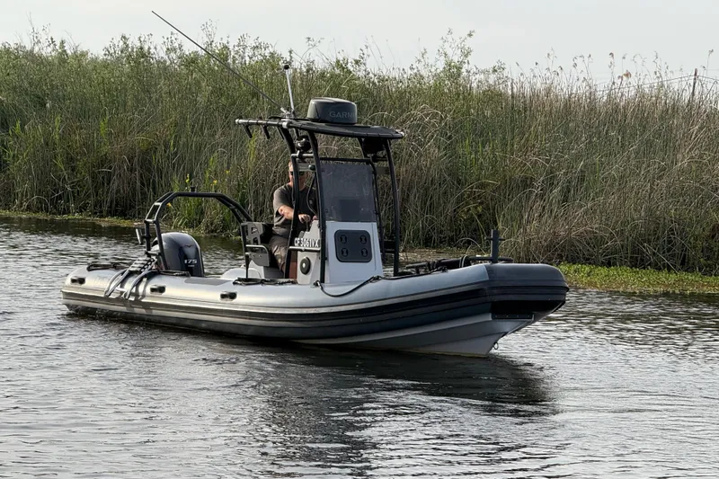 Slide: The Image of 2023 Inmar 660R-PT-PR boat navigating a calm waterway near lush reeds. - 19