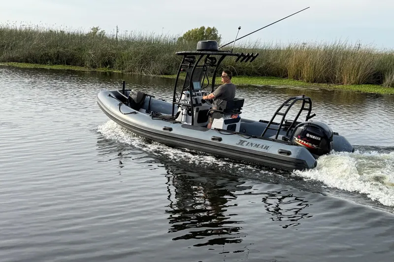 Slide: The Image of 2023 Inmar 660R-PT-PR boat cruising on a calm river with lush greenery. - 22