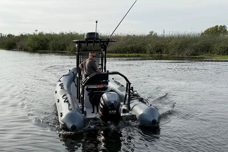 Slide: The Image of 2023 Inmar 660R-PT-PR boat navigating a calm river with a person and a dog onboard. - 23