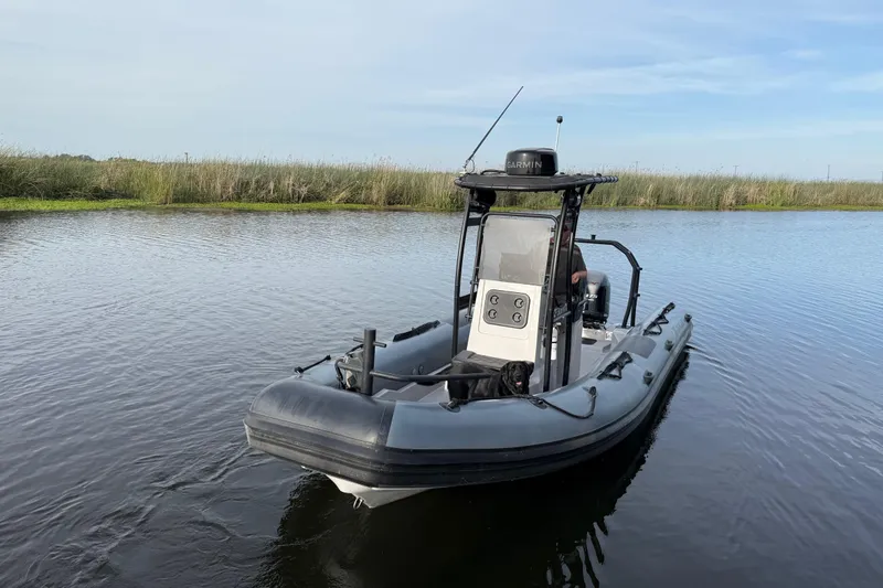 Slide: The Image of 2023 Inmar 660R-PT-PR boat on calm water with grassy shoreline. - 7