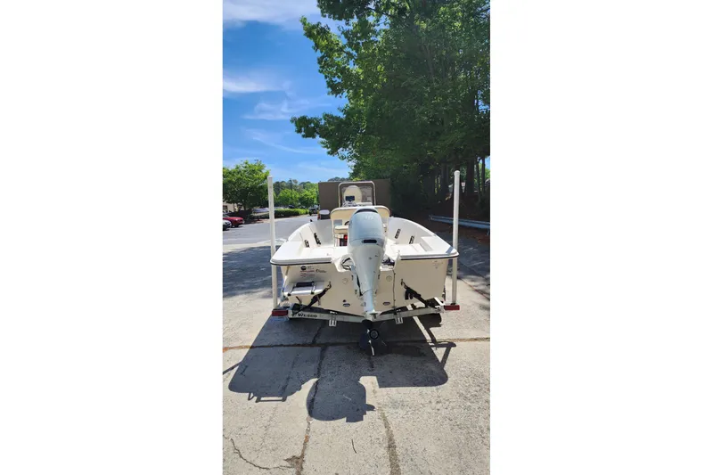 Slide: The Image of 2024 Carolina Skiff EV180 Sea Skiff boat with outboard motor, parked outdoors. - 4